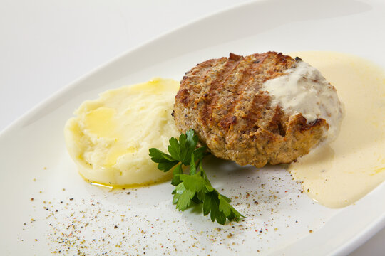Appetizing chop (cutlet) with mashed potatoes isolated on white background. Grilled meat