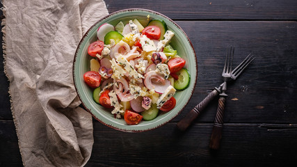Top view seafood salad with octopus, cucumber, radish, blue cheese and cherry tomatoes.