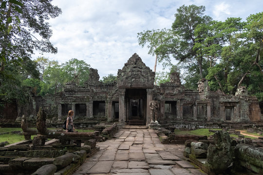 Side view of woman enjoying vacation while looking at ruins of religious temple of Angkor Wat in Cambodia