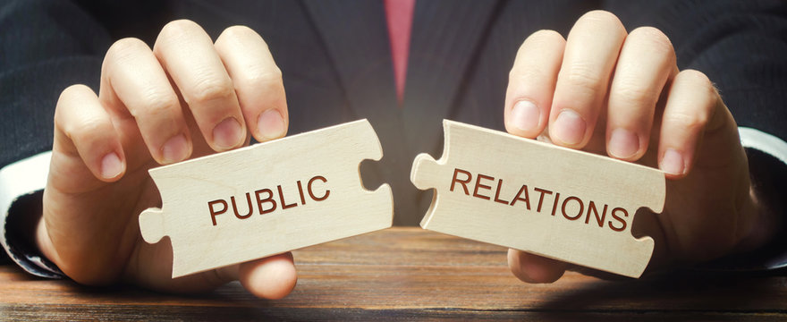 Businessman collects wooden puzzles with the words Public Relations. Management of information flows between the organization and the public. Social interaction. Strategic communication process.