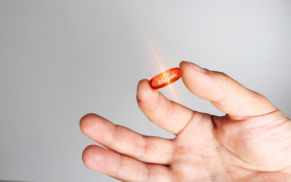 red capsule hiv medicine in hand lettering