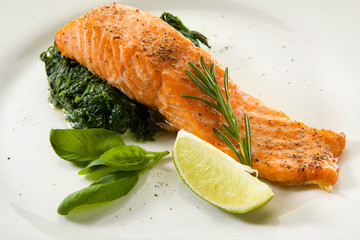 Appetizing grilled salmon steak with vegetables isolated on white background