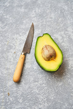 Cut avocado on grey texture background
