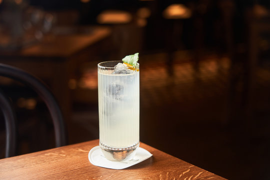 Vodka And Tonic Alcohol Cocktail In Highball Glass Decorated With Ice And Mint Leaves On Dark Background