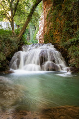 Idyllic Waterfall in rainforest landscape. Water flowing in tranquil scenery .