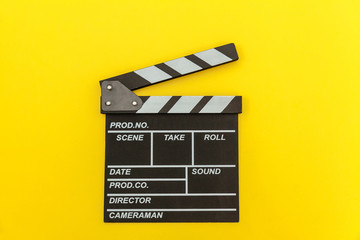 Fototapeta na wymiar Filmmaker profession. Classic director empty film making clapperboard or movie slate isolated on yellow background. Video production film cinema industry concept. Flat lay top view copy space mock up.