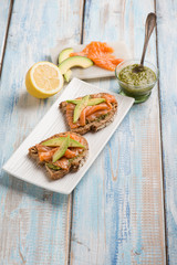sliced bread with pesto sauce smocked salmon and avocado