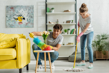 happy man and woman doing spring cleaning in apartment - Powered by Adobe