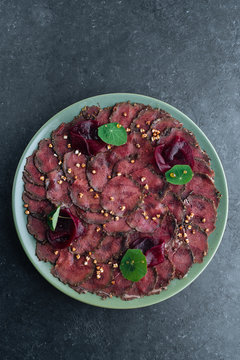 Overhead savory meat carpaccio served with boiled beetroot on plate in restaurant