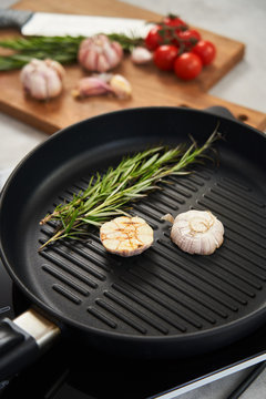 Grill pan with rosemary and garlic in kitchen