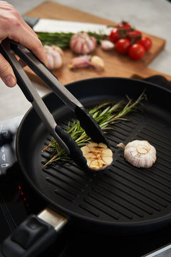 Grill pan with rosemary and garlic in kitchen
