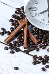 white retro alarm clock, flowers cup of coffee , coffee beans and cinnamon on a wooden table. Breakfast coffee. Morning. espresso	