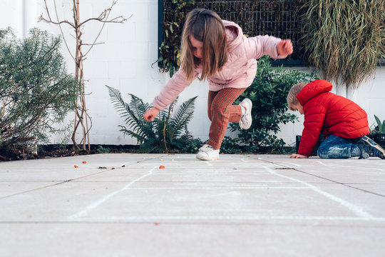 Children Playing Hopscotch In A Terrace Outdoors