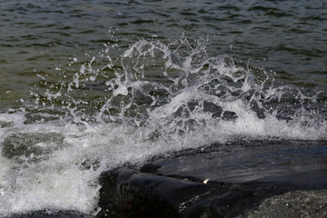 Waves hitting rocks in Helsinki, Finland. Beautiful photo representing the power and strength of the sea during windy weather. Waves can be dangerous but they also create beautiful splashes.
