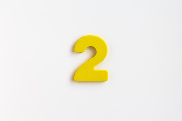 yellow painted wooden number two, craft sign for kid's education isolated, ecological concept