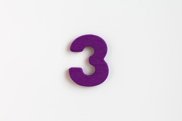 violet painted wooden number three, craft sign for kid's education isolated, ecological concept
