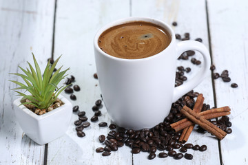 cup of coffee with cinnamon and coffee beans