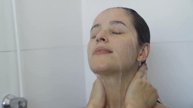 Spa woman showering relaxing under running water in hot shower