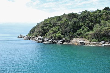 View from a ship towards the coast, Bombinhas, Brazil. A pier at the foot of the hill.