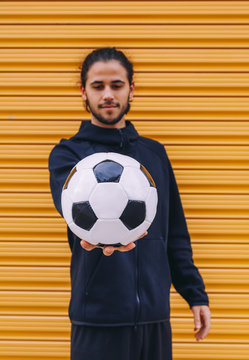 Man playing soccer ball on street