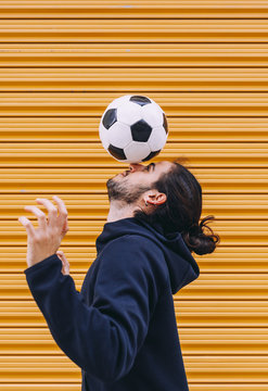 Man playing soccer ball with head