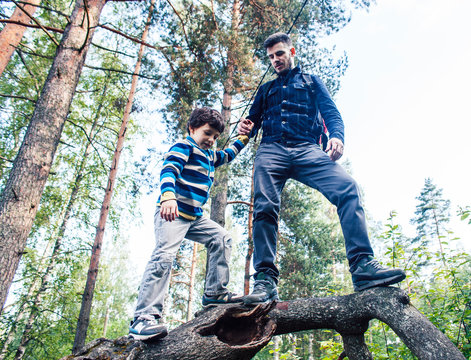 Little Son With Father Climbing On Tree Together In Forest, Lifestyle People Concept, Happy Smiling Family On Summer Vacations
