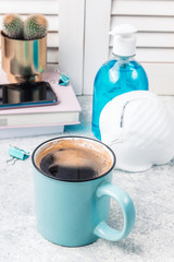 Layout flat lay on the theme of world quarantine by covid-19 and work at home. Notepad, graphic tablet, stylus, medical mask and protective spray on a clear blue background.