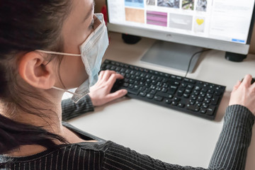 Business woman working from home wearing protective mask