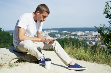 man holding digital tablet outdoors while he is working