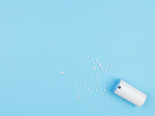Homeopathic granules against a blue background.