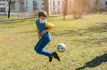 Boy playing football in the park despite the Covid-19 crisis