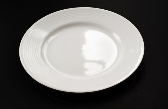 One white plate on black background