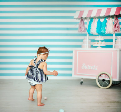 Small Girl Near Decorative Wooden Cart With Candy Bar