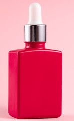 cosmetic raspberry bottle on pink background