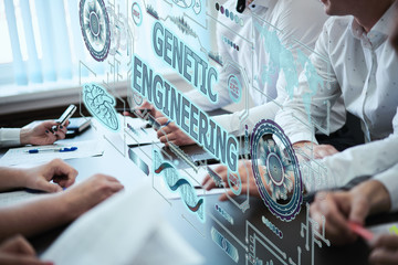 Business, technology, internet and network concept. A group of young people works with a hologram on the screen see the inscription: GENETIC ENGINEERING