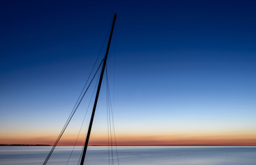 Schiffsmast im Abendlicht am Meer