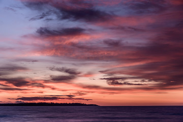 Naklejka na ściany i meble Sonnenuntergang am Meer mit beeindruckendem Himmel und Wolken