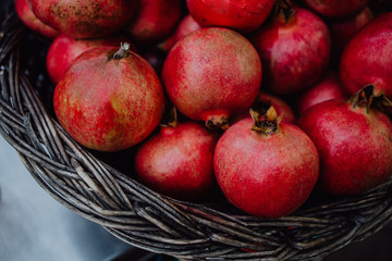 Basket full of red fresh pomegranate close up