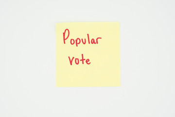 Popular vote written on a yellow sticky note with copyspace. Presidential election 2020