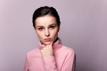 beautiful girl in a pink turtleneck on a gray background