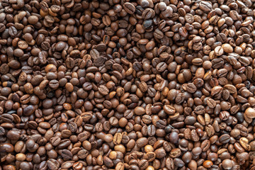 roasted brown coffee beans top view. rough surface texture