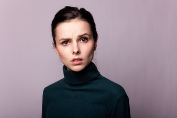 Fototapeta premium beautiful girl in a green turtleneck on a gray photo