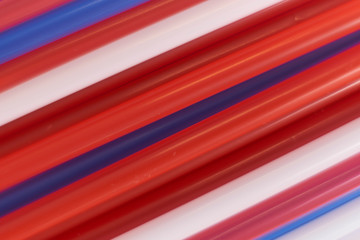 Colored cocktail plastic drinking straws rotates on white color background.
