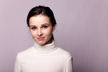 girl in a white turtleneck, portrait on a gray background