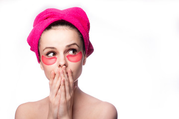 young woman after a shower in a pink towel and patches