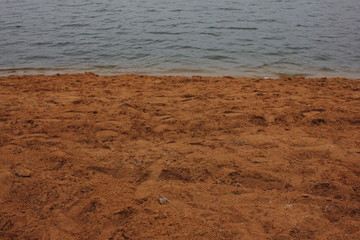 Empty sandy beach and waves on the river. Quiet landscape in warm colors.