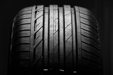 Studio shot of brand new car tire isolated on black background. close up