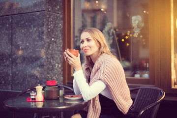 Woman drinks coffee outside of cafe