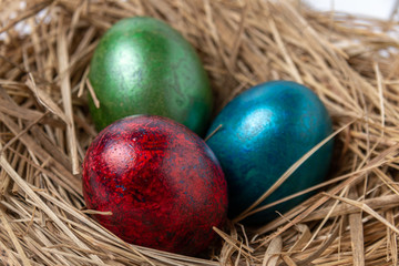 Fototapeta na wymiar Shiny colorful easter egg in nest. Easter Eggs concept