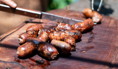 Argentine grill, cutting sausages. Argentinian barbecue